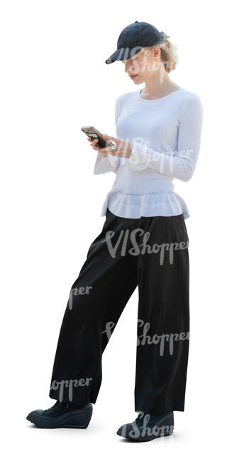 woman with a baseball hat standing and texting