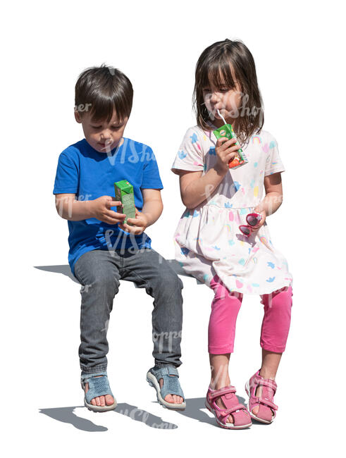 two kids with juice boxes sitting and drinking