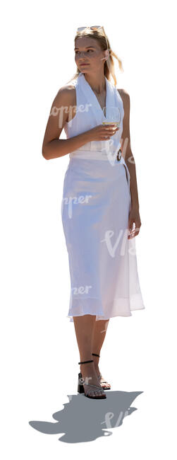 backlit elegant woman in a white dress standing and drinking wine