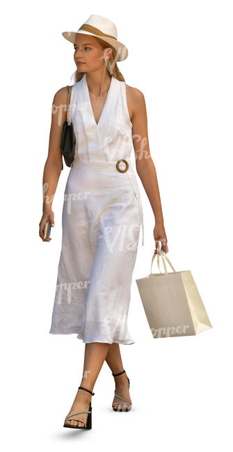 woman in an elegant white dress and wearing a hat walking