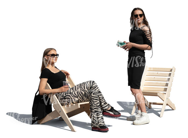 one woman standing and and one woman sitting and looking around