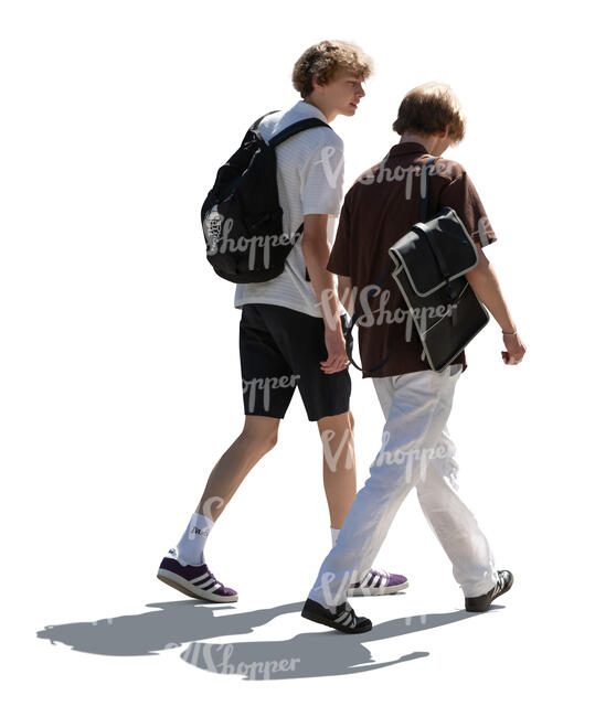 two backlit teenage boys walking