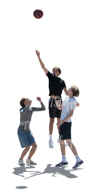 backlit group of teenage boys playing basketball