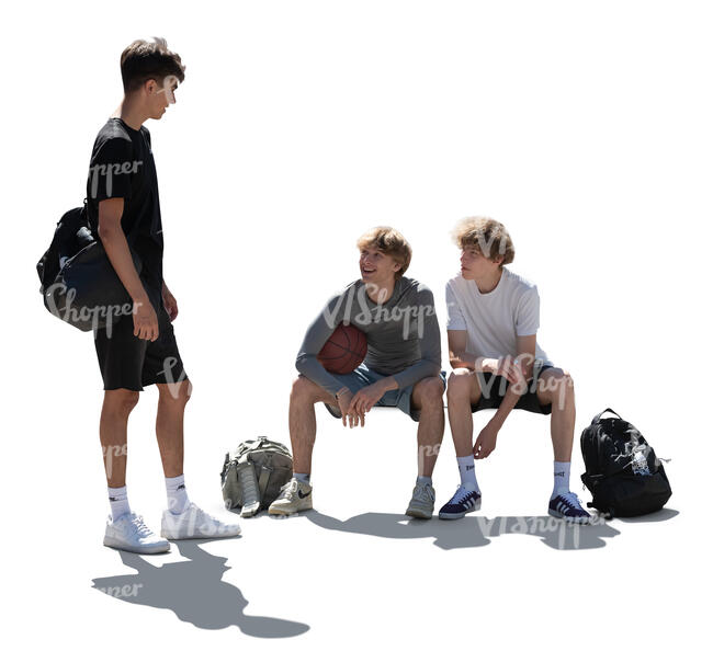 backlit group of teenage boys sitting and standing
