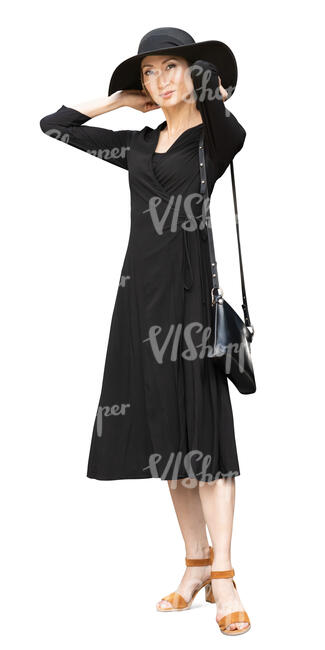 asian woman in a black dress and wearing a black hat standing