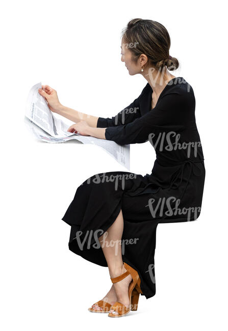 asian woman in a black dress sitting at a table and reading a newspaper