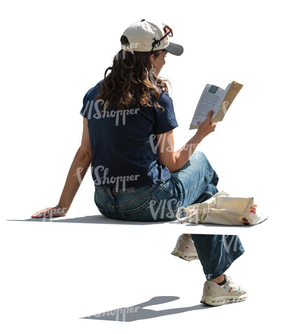 back angle view of a woman sitting outside and reading
