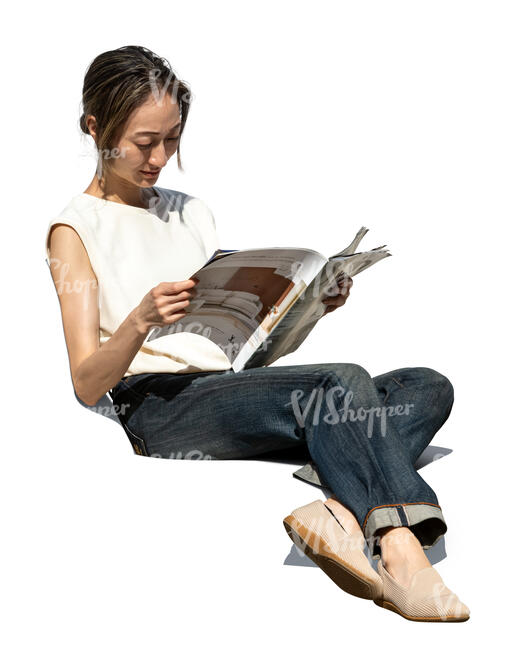 asian woman sitting on a sofa and reading a magazine