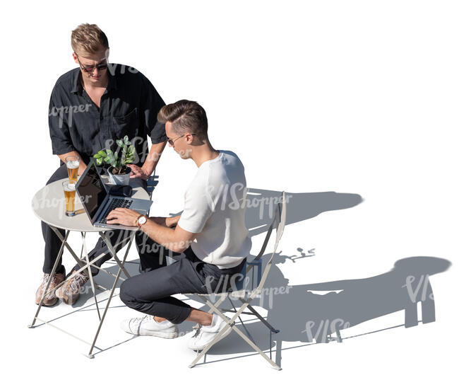 top view of two men sitting in a cafe and looking at a laptop