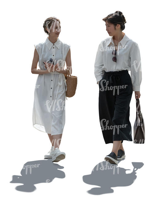 two backlit asian women walking