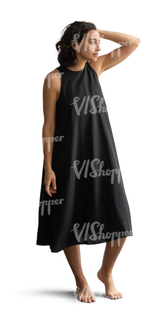 woman in a black dress standing barefoot at home
