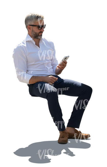 man in a suit sitting outside in backlight