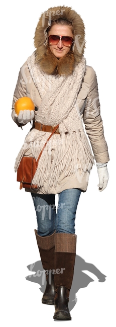 woman walking with an orange in her hand