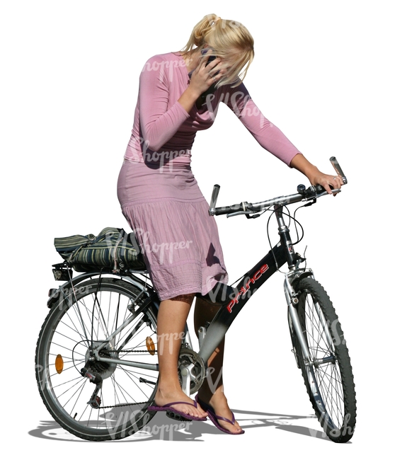 blond woman standing with a bike while on the phone