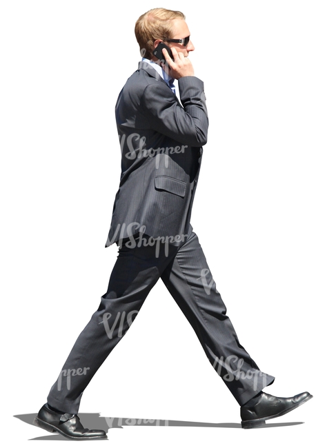 man in a suit walking and talking on the phone