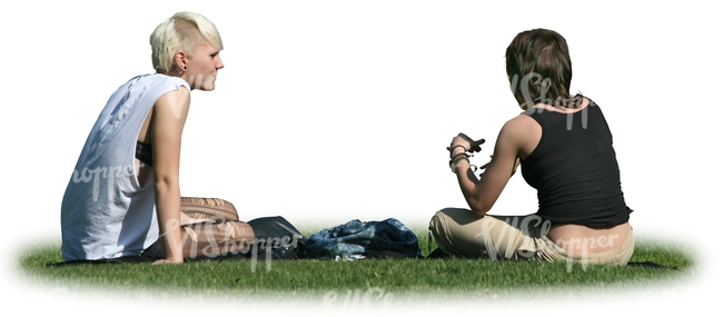 two women sitting on the grass