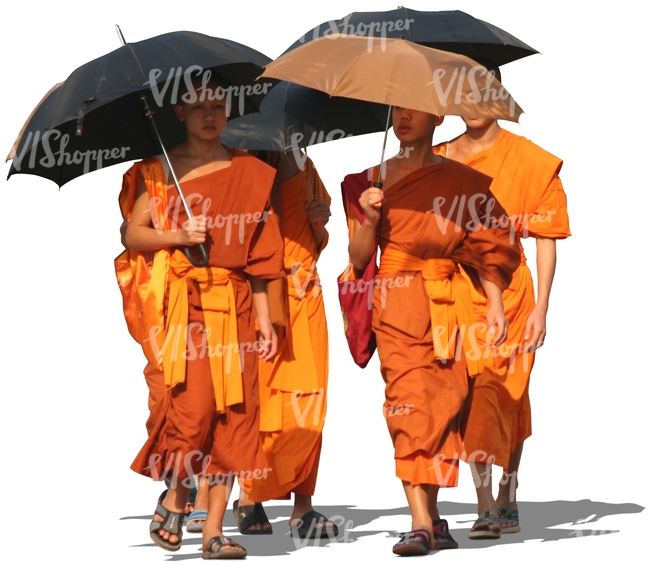 four buddhist monks walking with umbrellas