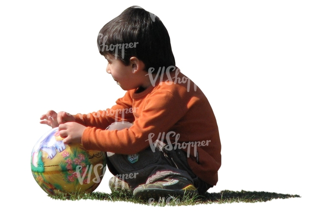 boy with a ball squatting on the grass