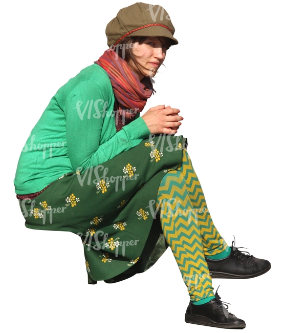 bohemian woman in a green outfit sitting