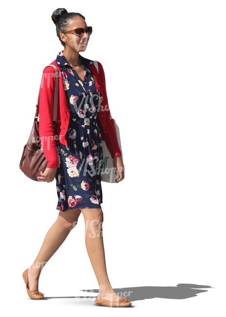 black woman in a blue dress walking and smiling