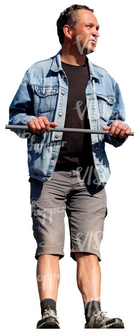 man in a denim jacket standing against the railing