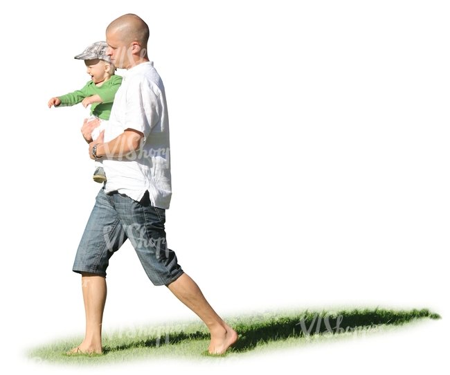 man walking on the grass hoding his son in his arms 