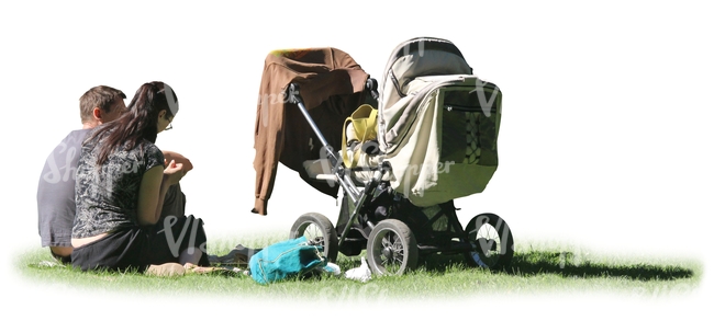 man and woman with a baby carriage sitting on the grass