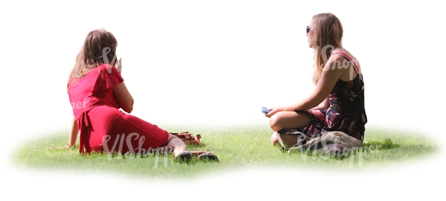 two women sitting together on the grass