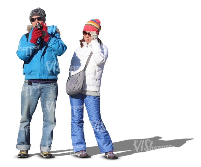 man and woman in winter clothes standing and taking pictures