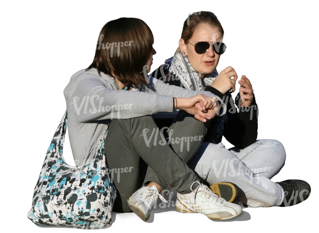 two girls sitting and talking on the sidewalk