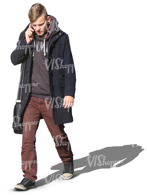 man in a black autumn coat walking and talking on the phone
