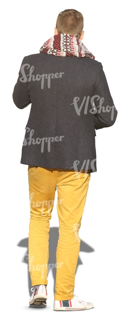 man with a big scarf and yellow trousers seen from behind