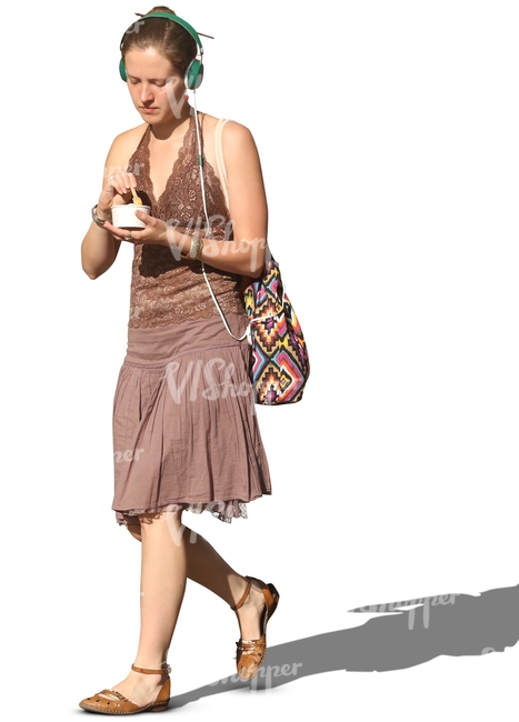 woman with headphones walking and eating icecream