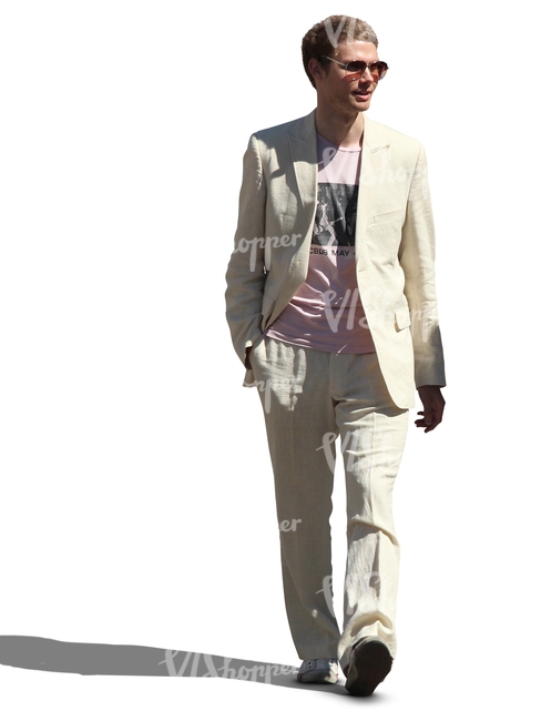 man in a white suit walking and smiling