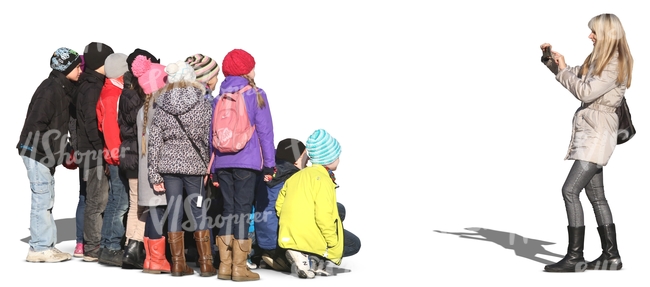 woman taking a picture of a group of children