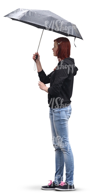 red-haired woman in jeans standing under an umbrella