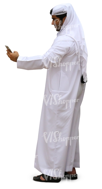 arab man in a white thobe looking at his phone