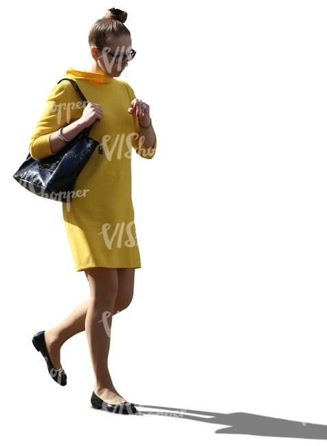 cut out backlit woman in a yellow dress walking