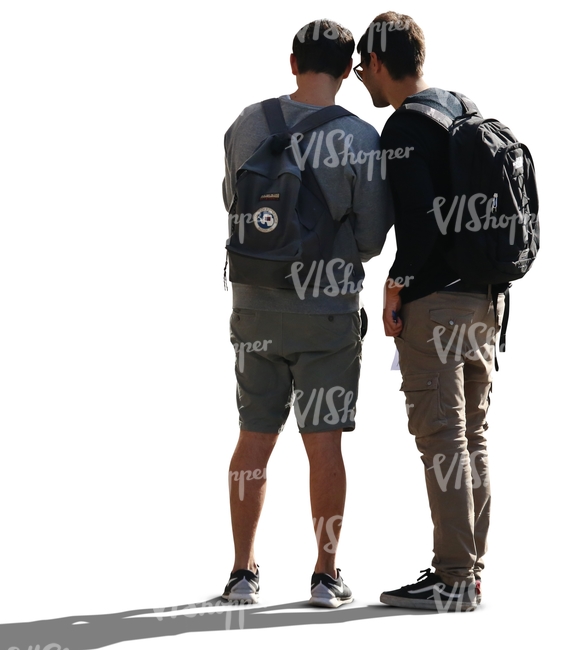 two backlit men standing and looking at smth