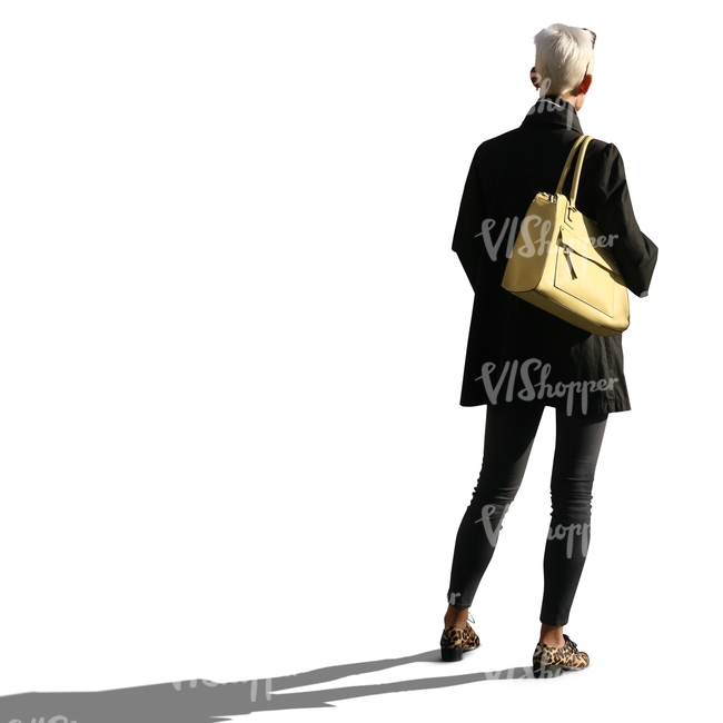 backlit woman with a yellow purse standing