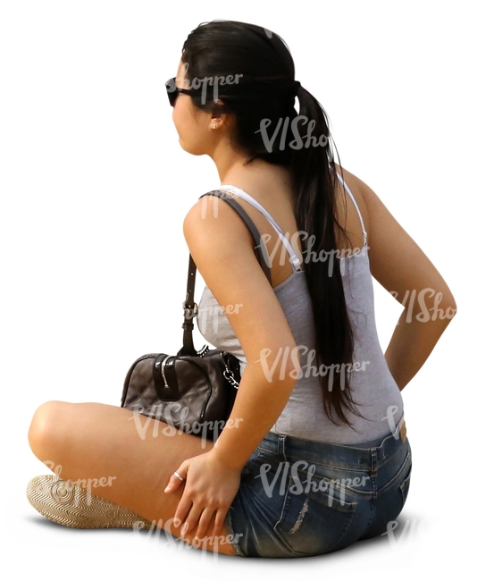 woman with long dark hair sitting on the ground 