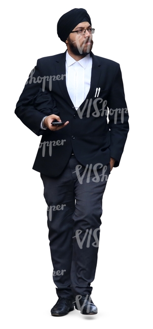 hindu businessman with a turban walking with a phone in his hand