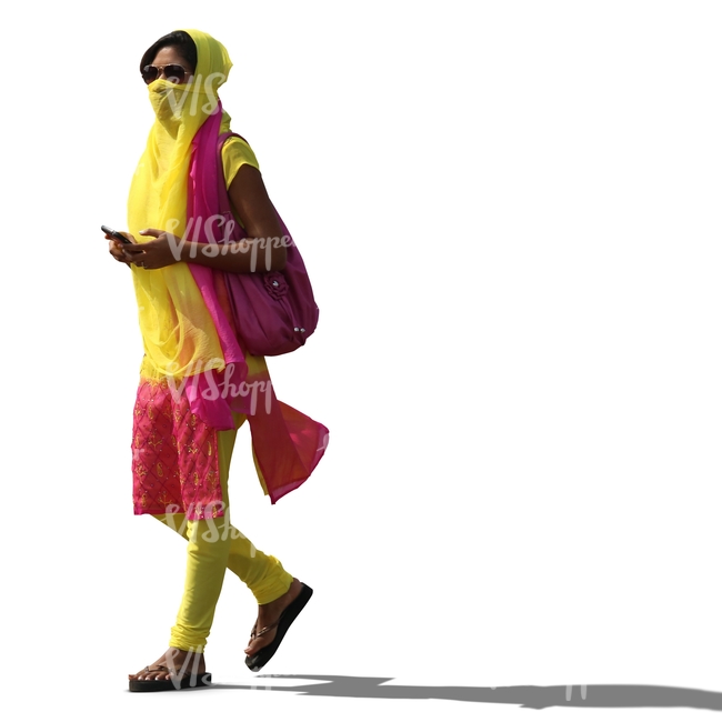 young hindu woman in a clorful outfit and holding a phone walking 