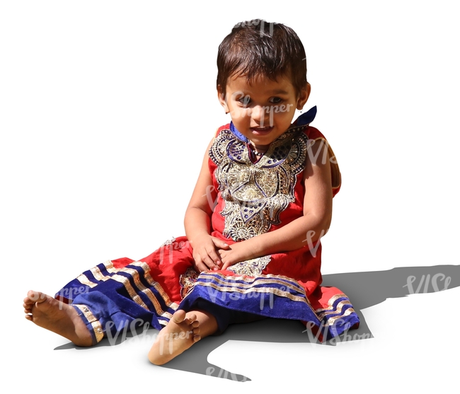 little hindu girl in a fancy dress sitting no the ground