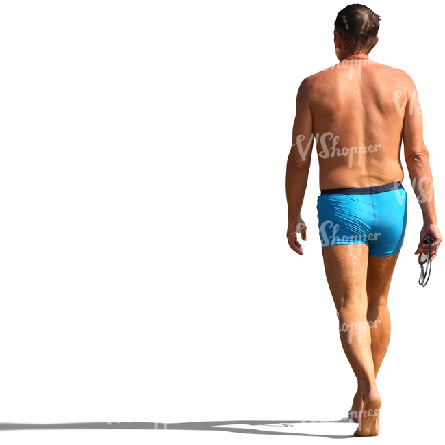 man in a bathing suit walking on the beach
