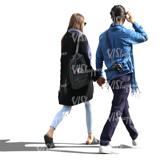 backlit man and woman walking hand in hand