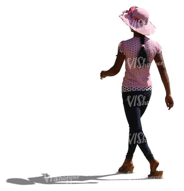 backlit black woman wearing a pink hat walking