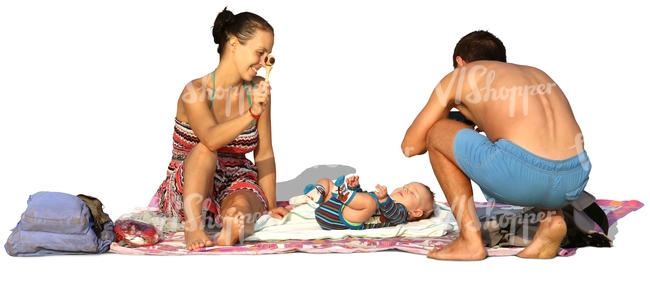 family with a small baby relaxing on the beach