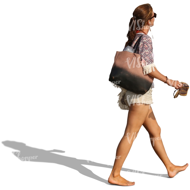 woman walking on the beach and carrying her sandals