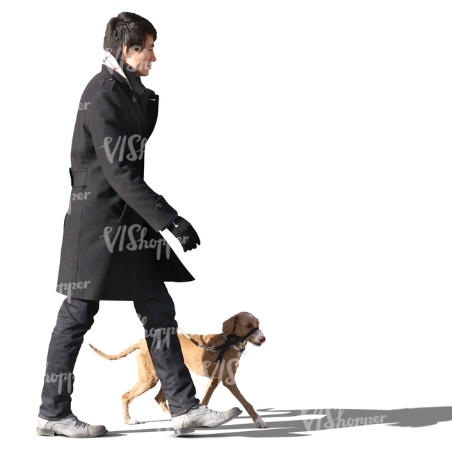 asian man in a black coat walking a dog